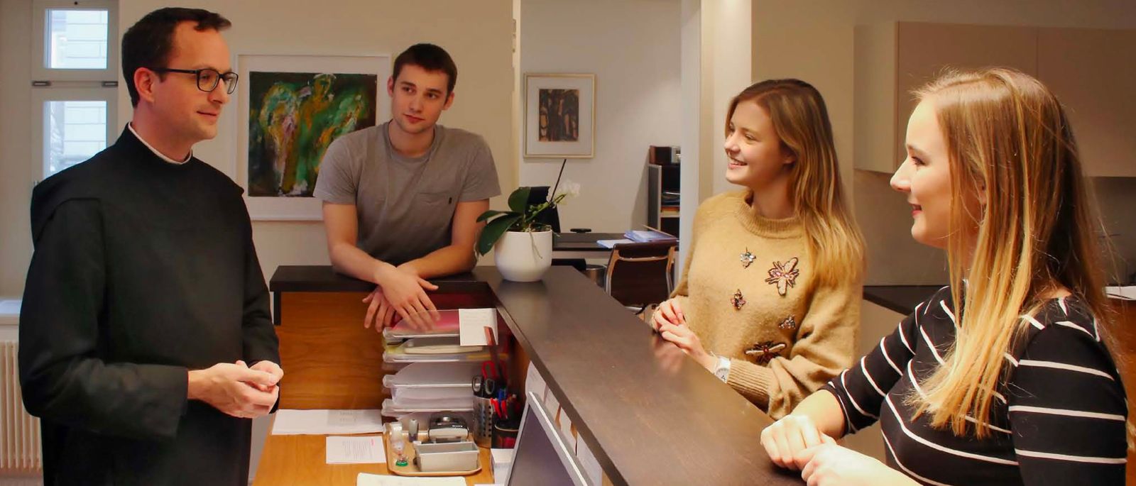 Mentor em conversa com estudantes em ambiente acolhedor